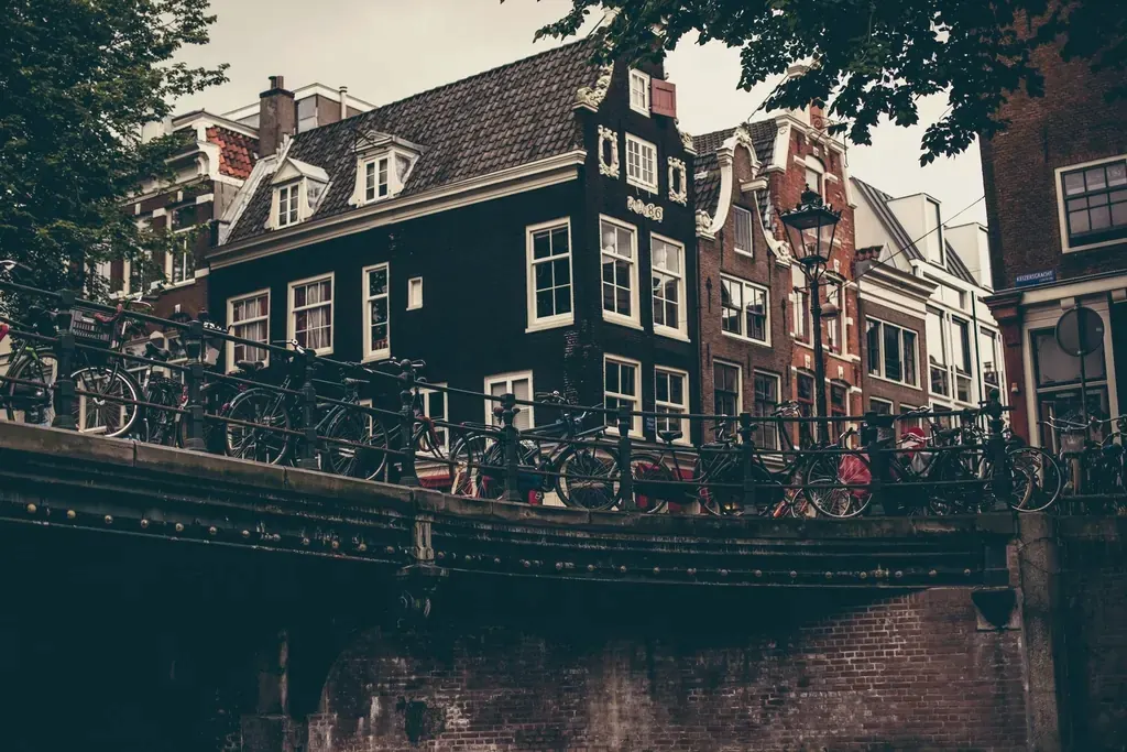 Grachtenpanden met fietsen op de brug in de schemering