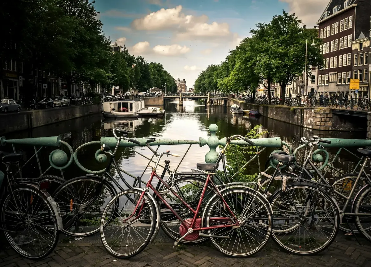 Rij geparkeerde fietsen tegen een brugleuning aan een Amsterdamse gracht