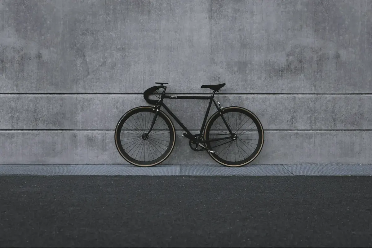 Zwarte fiets tegen een betonnen muur